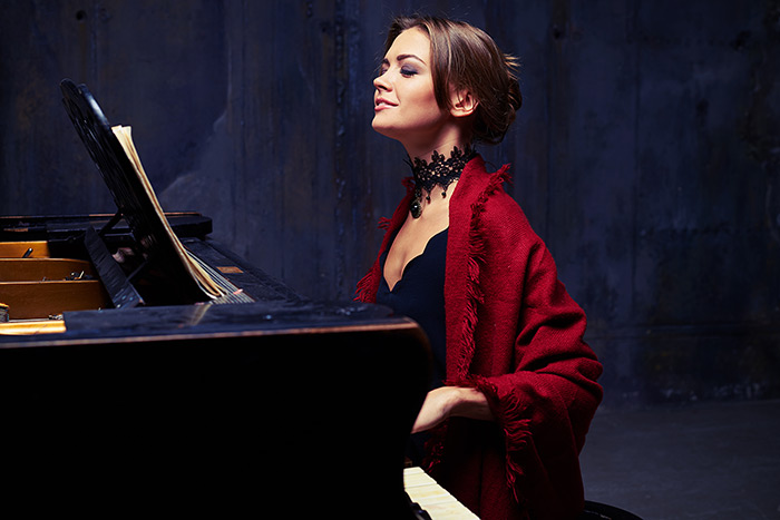 A beautiful woman enjoys playing piano feat