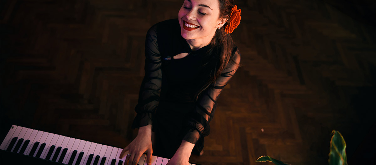 Beautiful woman happily playing piano