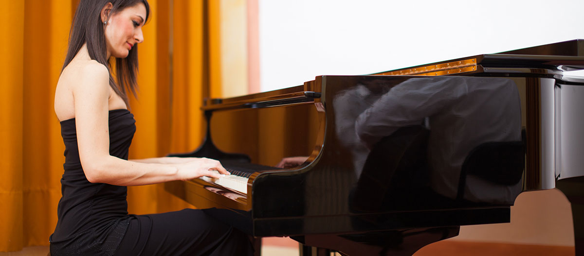 Beautiful woman playing the grand piano