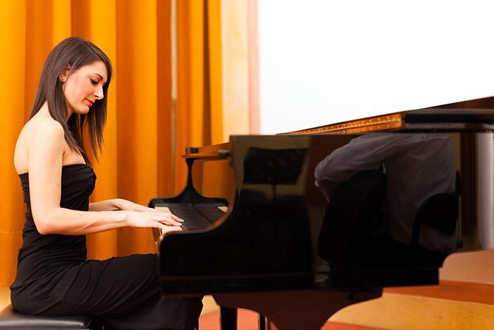 Beautiful woman playing the grand piano feat