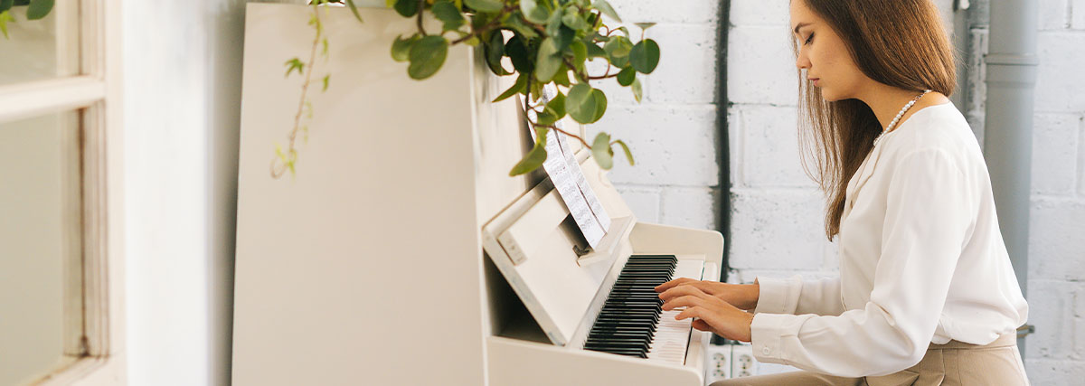 Beautiful woman playing white color piano