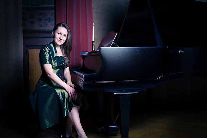 Beginner piano student in front of piano