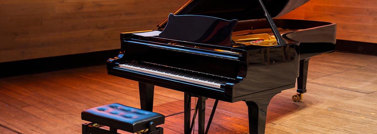 Black grand piano with chair in the room