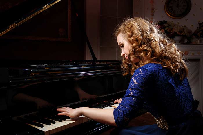 female pianist playing the piano feat