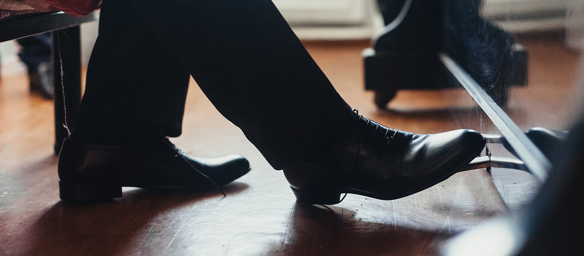 Foot stepping on the piano pedal