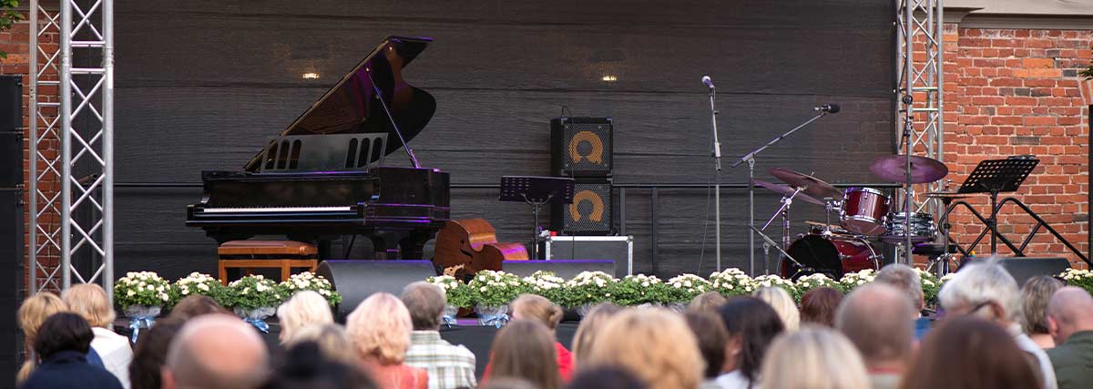 Grand piano and music instruments on concert stage with audience