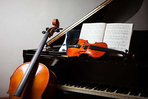 Grand piano with musical score and cello and violin
