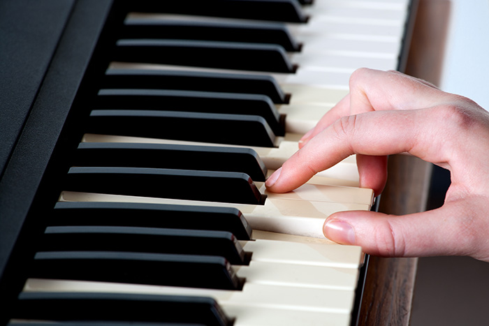 Hand playing piano feat