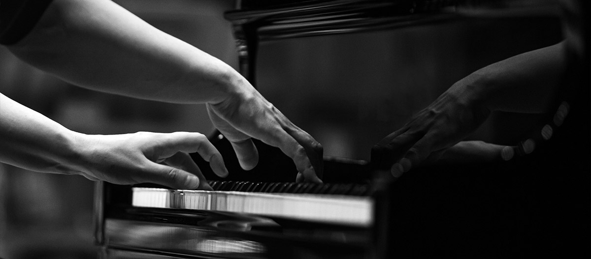 Hands playing piano black and white
