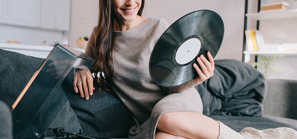 Lady changing a vinyl on her vinyl player