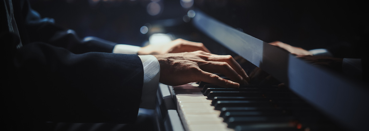 Male hands playing the grand piano