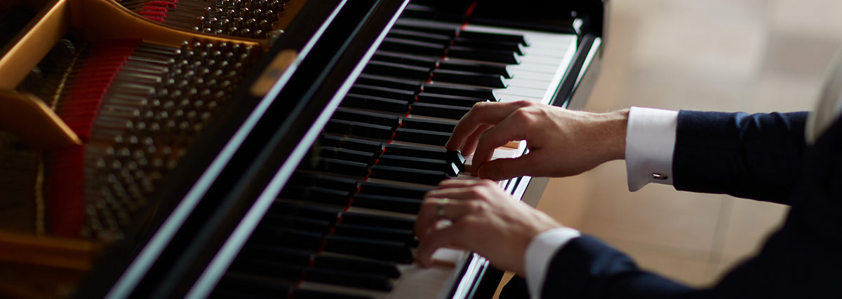 Male hands playing the grand piano