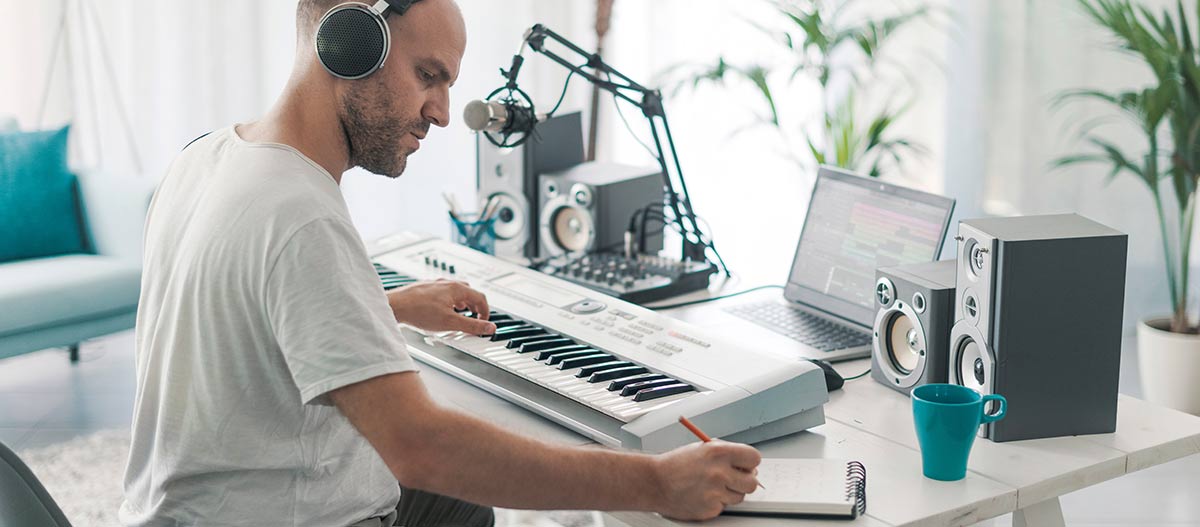 Man composing music while playing piano