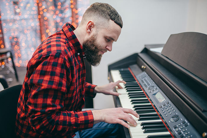 Man focused on playing piano feat
