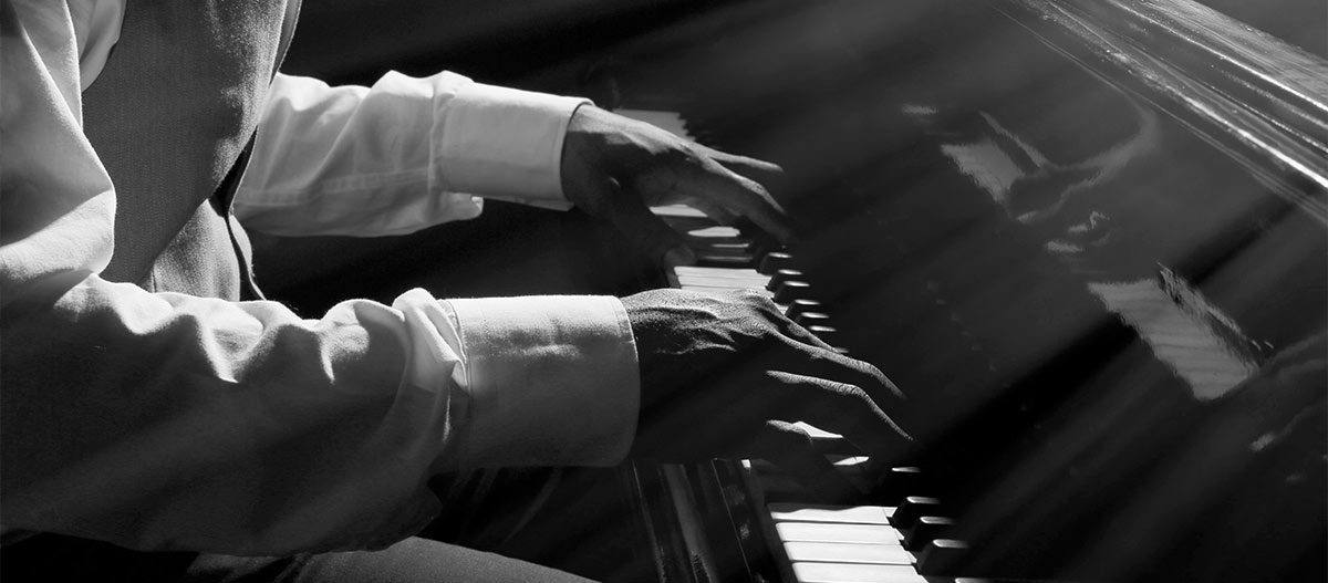 Man hands playing piano black and white photo