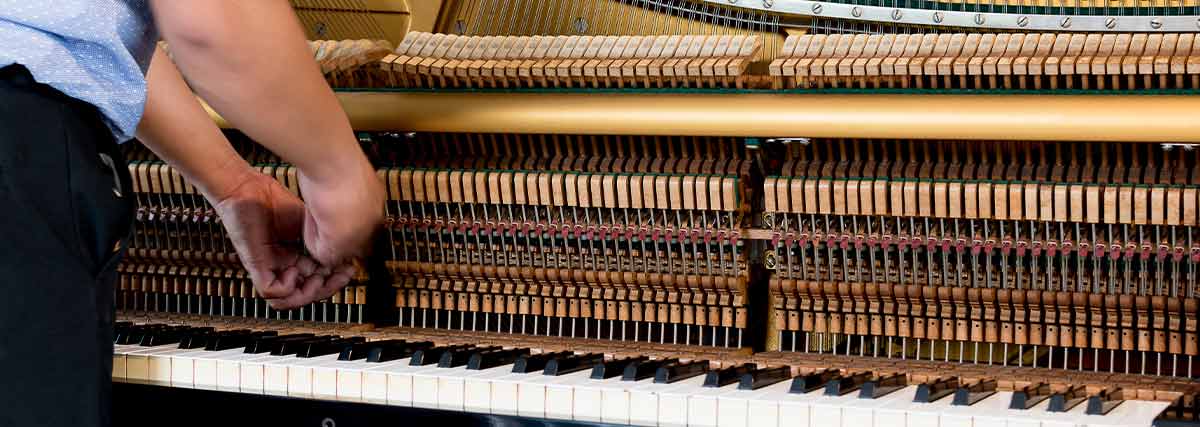 Man maintaining piano