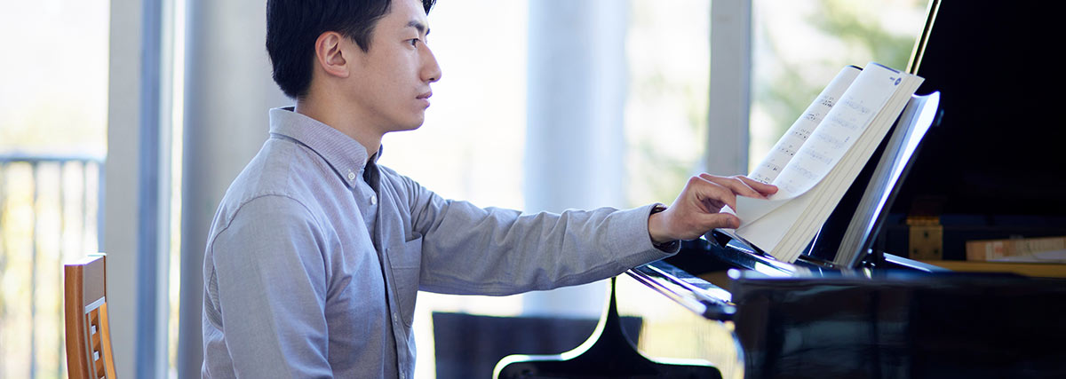 Man playing a piano with sheet music