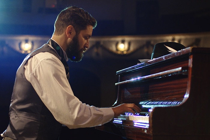 Man playing grand piano feat