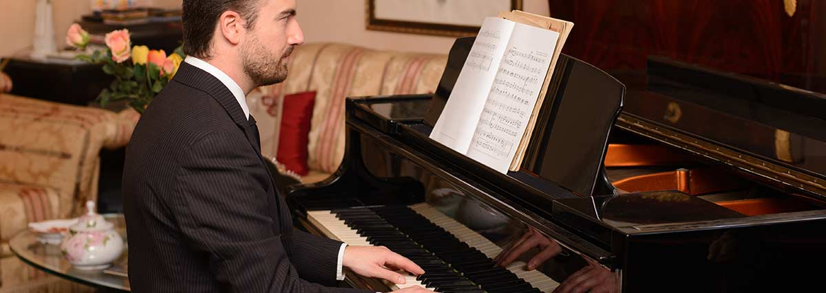 man-reading-music-on-piano