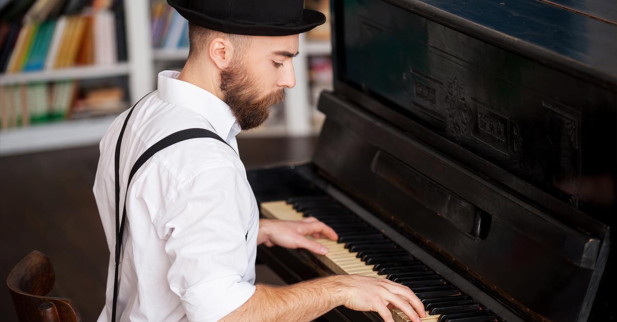 Man wearing a hat playing piano