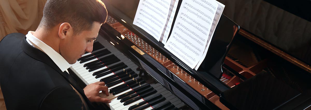 Man wearing a suit playing piano