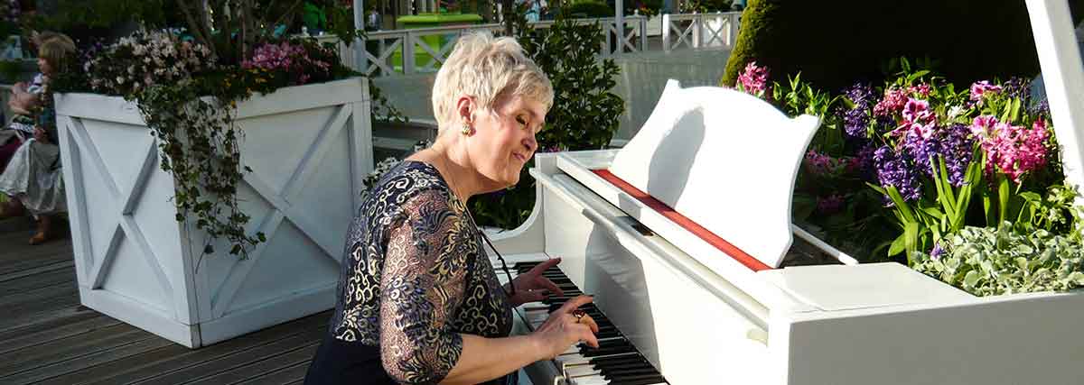 old woman playing the piano outdoor
