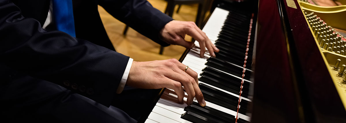 Pianist performing on a grand piano