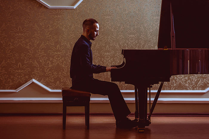 Pianist performing on a grand piano