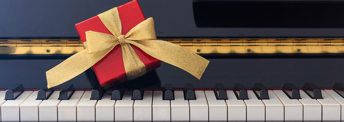 Red box gift with golden color tie on the piano