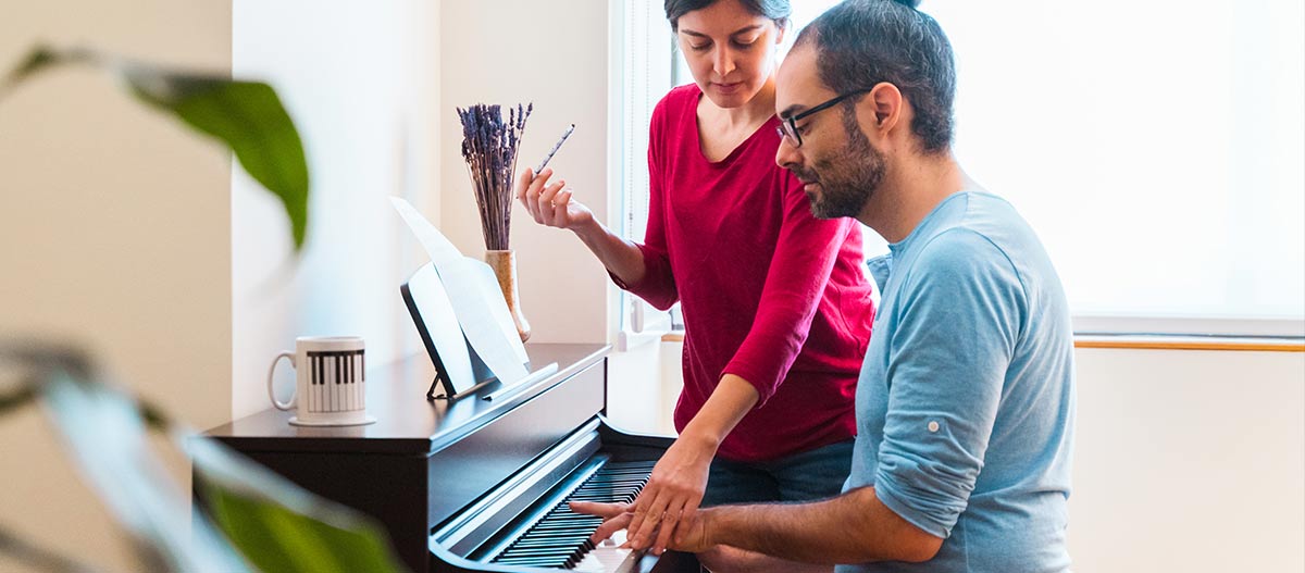Teacher and student having piano lesson