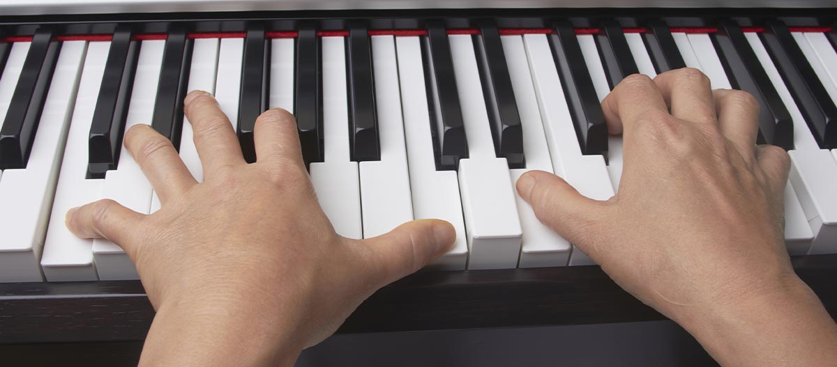 Two hands playing on the piano
