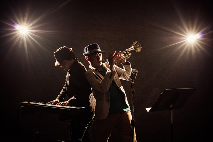 Two musicians playing piano and trumpet together feat