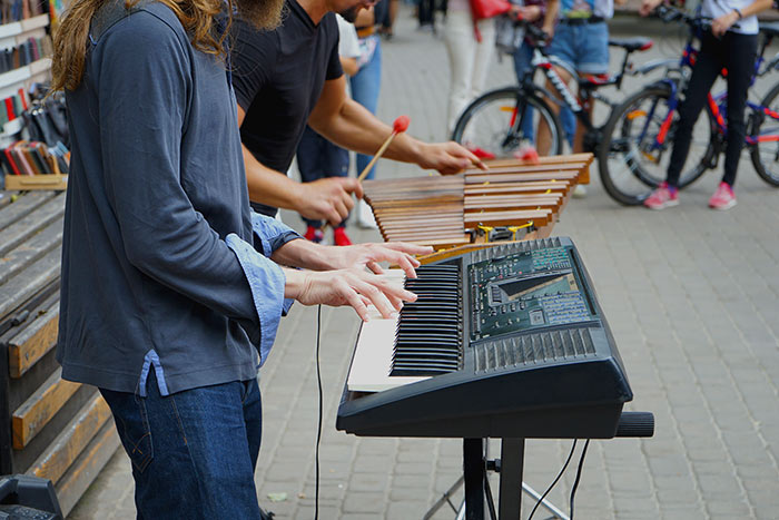 Two musicians playing piano and xylophone on the street feat