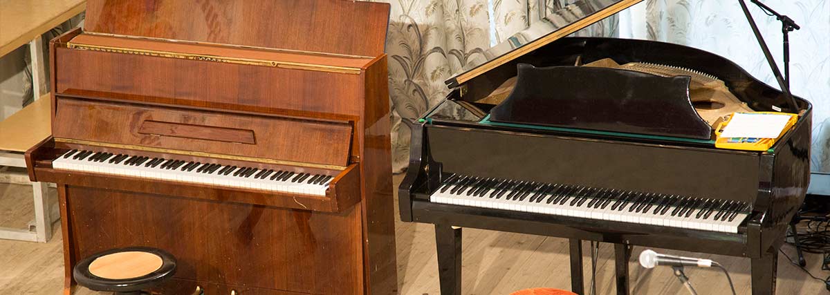 Upright and grand piano in a room
