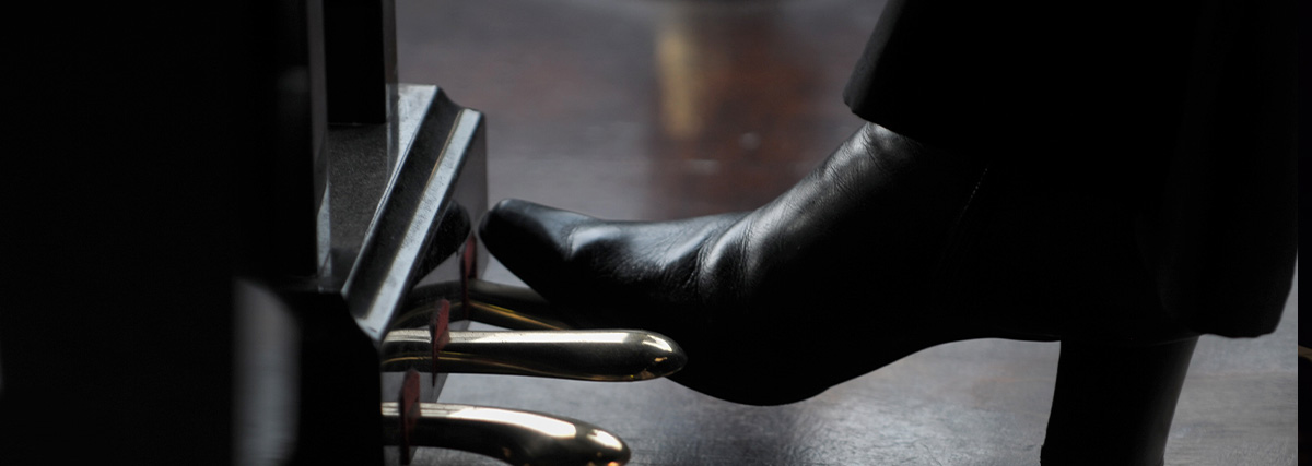 Woman foot stepping on piano pedal
