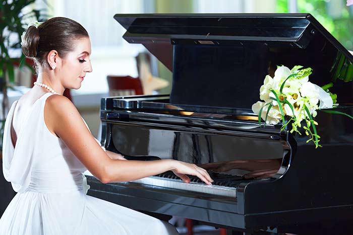 woman in white playing the piano feat