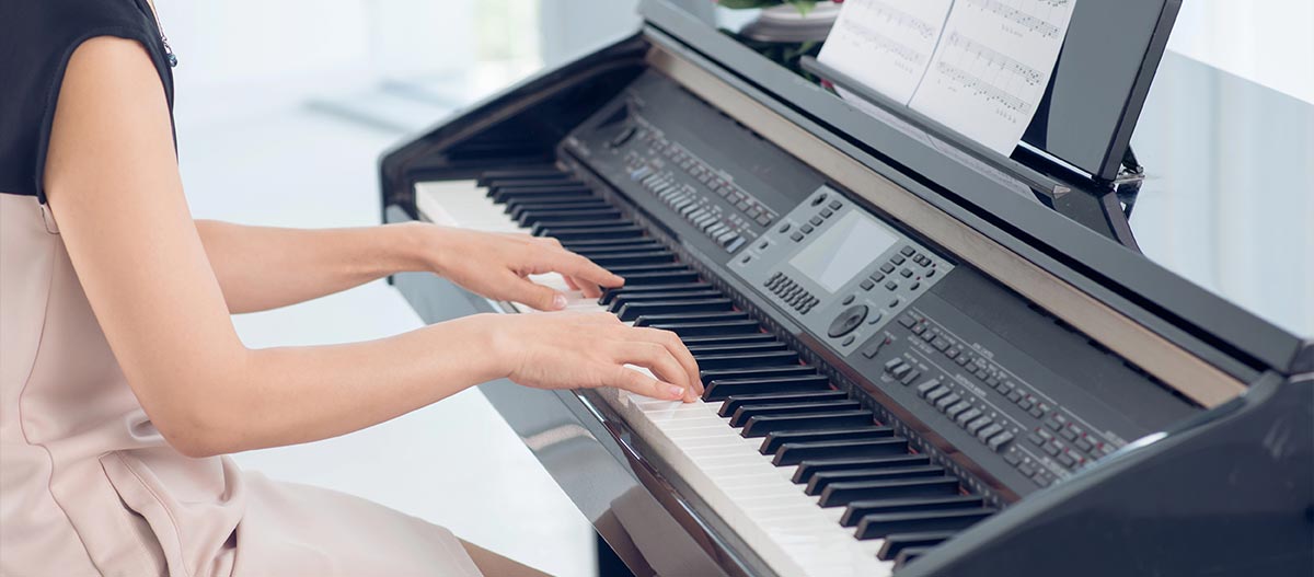 Woman playing digital piano at home