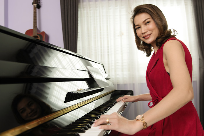 Woman smiling playing piano feat