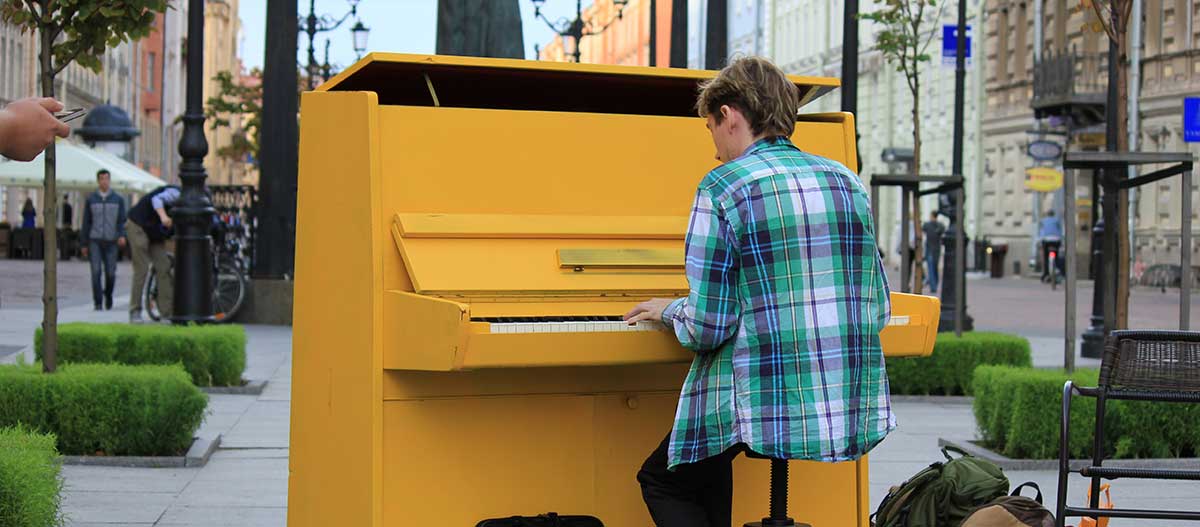 Young man playing the upright piano on the street